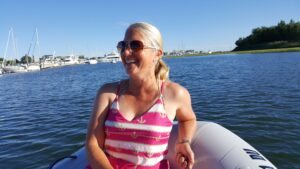 Anne in the dinghy with shades on